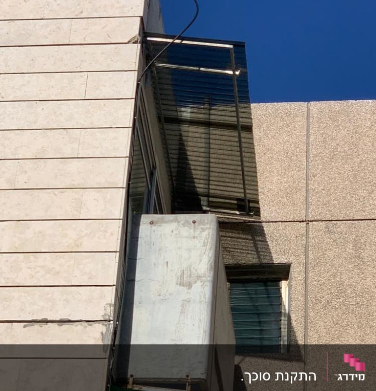 סוכך זכוכית מעל חלון עם מסגרת מתכת